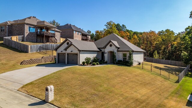 view of front facade with fence, a front lawn, brick siding, a garage, and driveway