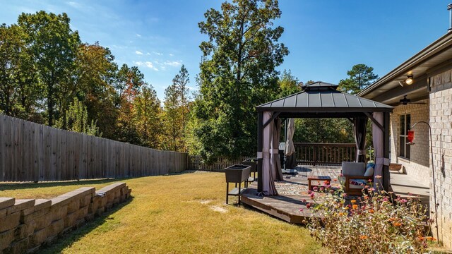 view of yard with a gazebo, a fenced backyard, a wooden deck, and an outdoor living space
