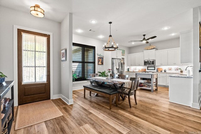 dining area featuring visible vents, baseboards, recessed lighting, light wood finished floors, and ceiling fan with notable chandelier