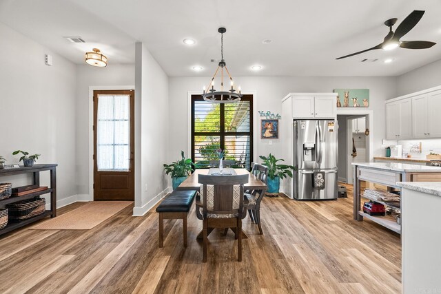 dining area with visible vents, baseboards, ceiling fan with notable chandelier, light wood finished floors, and recessed lighting
