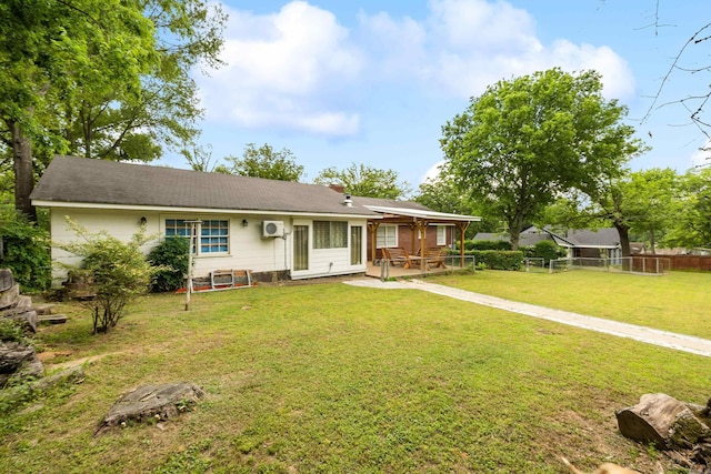 view of front facade featuring fence, a patio area, roof with shingles, and a front yard