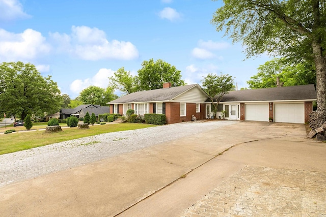 ranch-style house with brick siding, a garage, a chimney, and concrete driveway