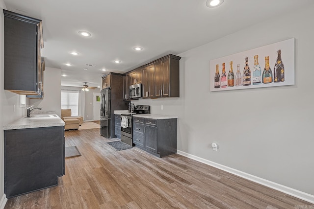 538 Maple St, Trumann, AR 72472 - kitchen with a ceiling fan, appliances with stainless steel finishes, a sink, baseboards, and light wood finished floors