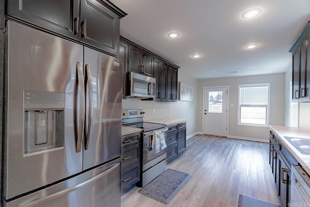 538 Maple St, Trumann, AR 72472 - kitchen with appliances with stainless steel finishes, light countertops, baseboards, recessed lighting, and light wood-style flooring