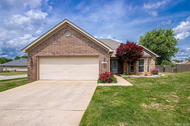 ranch-style house featuring fence, an attached garage, a front lawn, brick siding, and concrete driveway