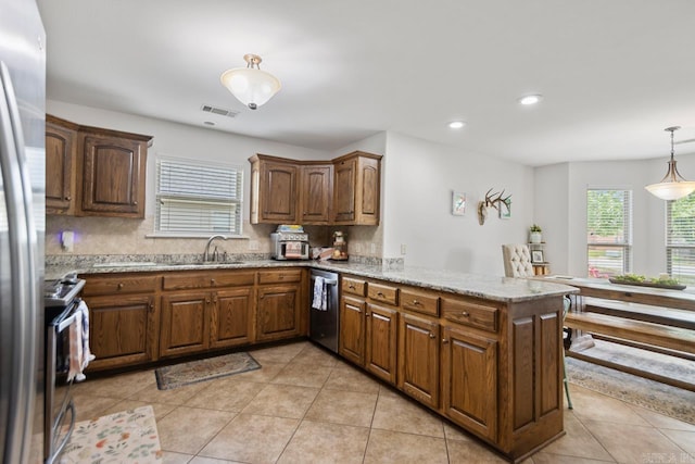 kitchen featuring a peninsula, tasteful backsplash, a sink, light tile patterned floors, and stainless steel appliances