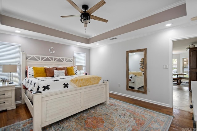 bedroom featuring visible vents, wood finished floors, and multiple windows