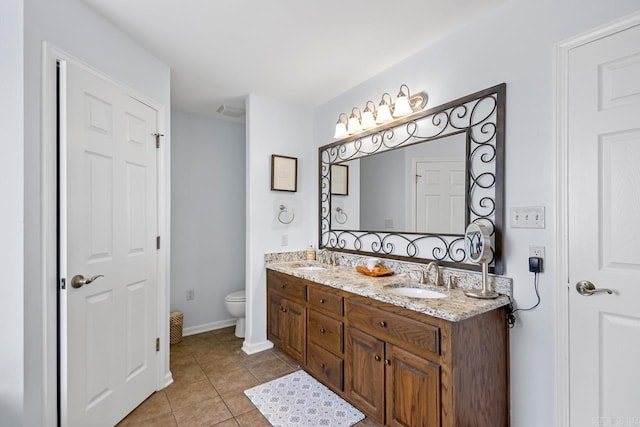 bathroom with a sink, tile patterned flooring, toilet, and double vanity