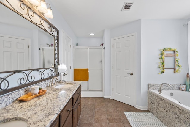 bathroom featuring tile patterned flooring, double vanity, visible vents, a sink, and a stall shower