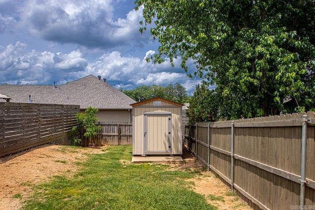 view of yard with an outbuilding, a fenced backyard, and a storage unit