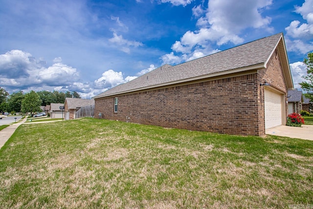 view of home's exterior featuring roof with shingles, a lawn, a garage, brick siding, and concrete driveway
