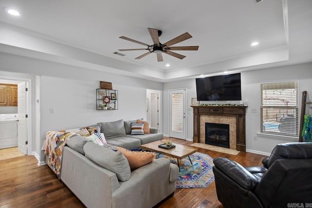 living room with visible vents, a ceiling fan, washer / clothes dryer, and a tray ceiling