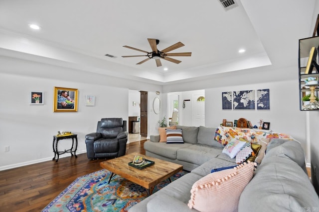 living area featuring a ceiling fan, recessed lighting, baseboards, dark wood-type flooring, and a tray ceiling
