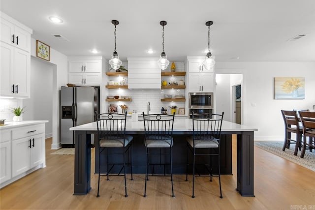 kitchen with open shelves, baseboards, light wood-style flooring, appliances with stainless steel finishes, and backsplash