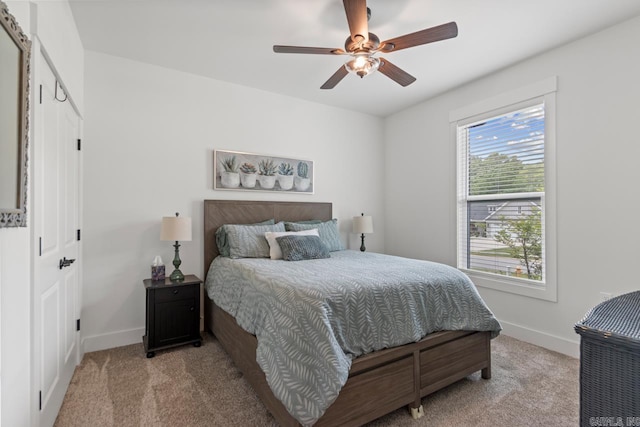 bedroom featuring a ceiling fan, baseboards, and light carpet