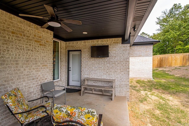 view of patio featuring ceiling fan and fence