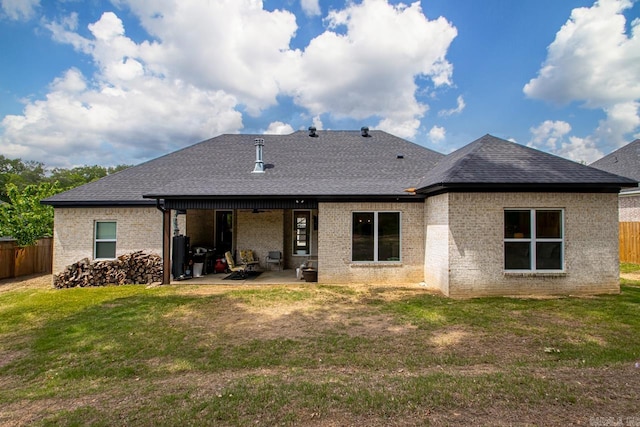 back of property with a patio, a fenced backyard, roof with shingles, and brick siding