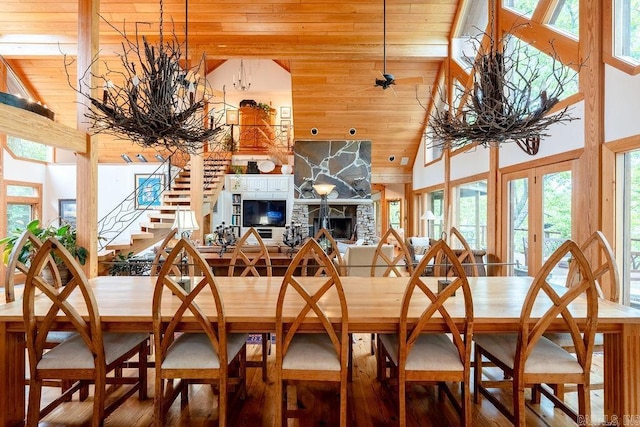 dining space featuring wooden ceiling, a wealth of natural light, stairway, and a fireplace