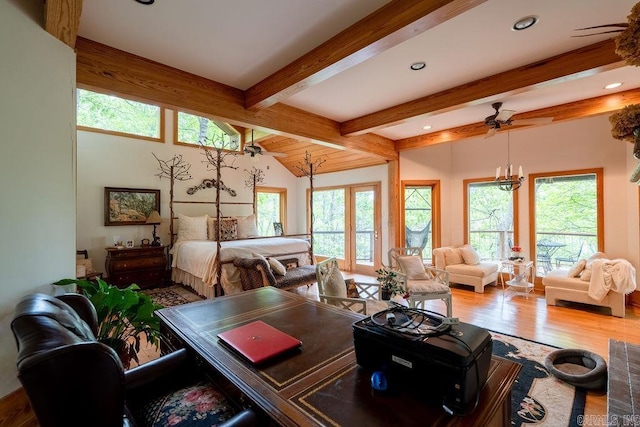 interior space with ceiling fan, lofted ceiling with beams, plenty of natural light, and wood finished floors