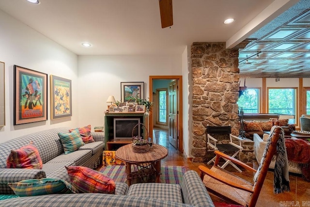 living area with recessed lighting and a stone fireplace