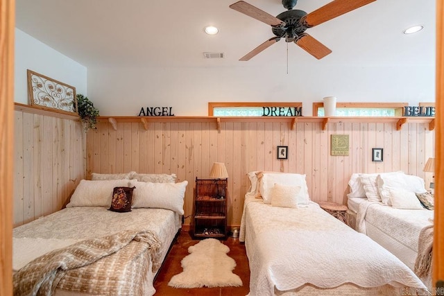 bedroom featuring wooden walls, recessed lighting, and visible vents