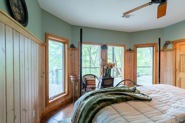bedroom with a ceiling fan, visible vents, access to exterior, and multiple windows