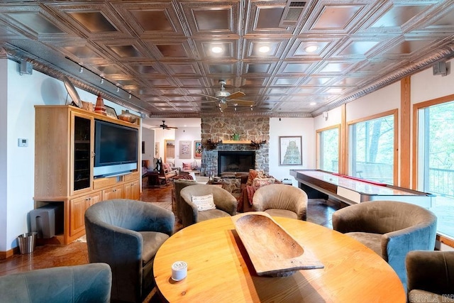living area with baseboards, ceiling fan, an ornate ceiling, and a fireplace