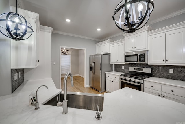kitchen with white cabinets, stainless steel appliances, a notable chandelier, and decorative backsplash