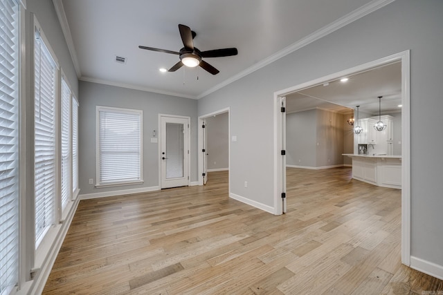 unfurnished living room with ceiling fan, visible vents, baseboards, ornamental molding, and light wood-style flooring