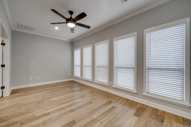 unfurnished room featuring crown molding, ceiling fan, baseboards, light wood-type flooring, and visible vents