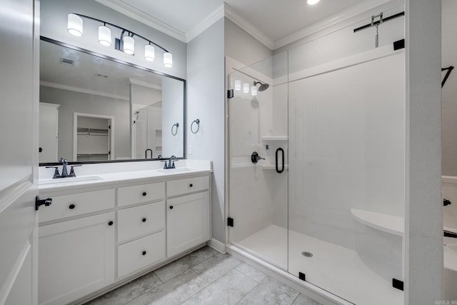 bathroom with crown molding, a sink, and a stall shower