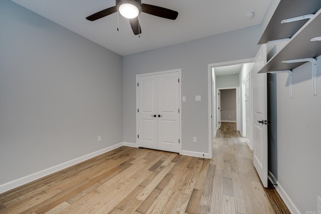 unfurnished bedroom featuring a closet, baseboards, a ceiling fan, and light wood-type flooring