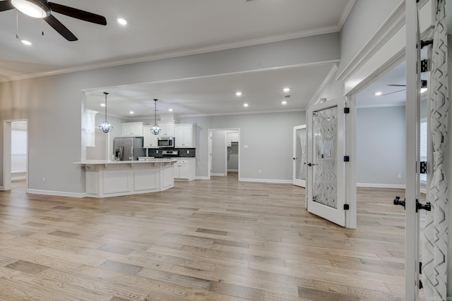 unfurnished living room featuring crown molding, a ceiling fan, light wood-style flooring, and recessed lighting