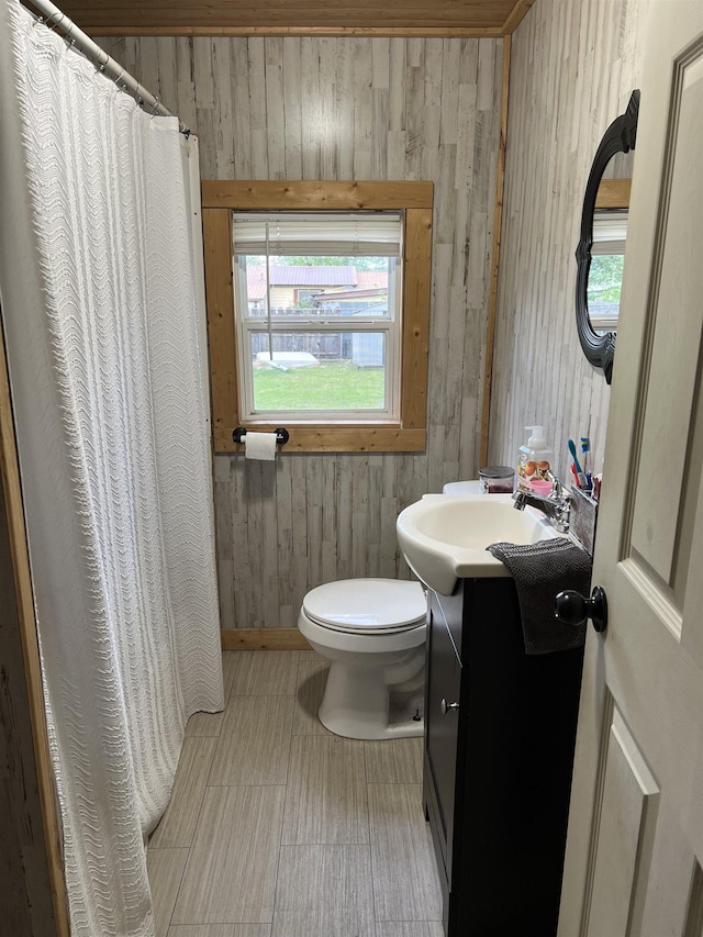 1008 Lange St, Leachville, AR 72438 - full bathroom featuring wooden walls, vanity, toilet, and curtained shower