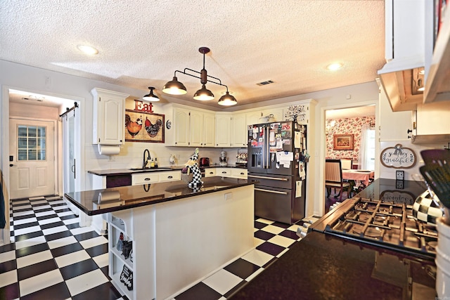 6311 Country Ln, Pine Bluff, AR 71603 - kitchen with visible vents, dark countertops, a sink, refrigerator with ice dispenser, and light floors