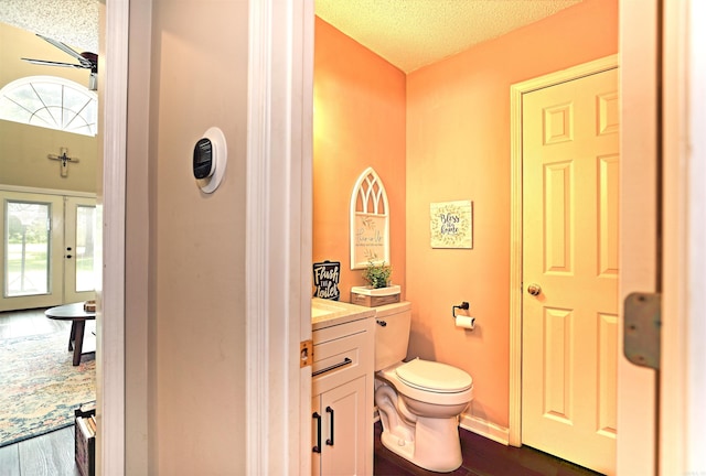 6311 Country Ln, Pine Bluff, AR 71603 - bathroom featuring vanity, a textured ceiling, wood finished floors, and toilet