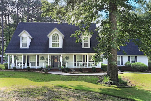 6311 Country Ln, Pine Bluff, AR 71603 - cape cod-style house featuring a porch, a shingled roof, and a front yard