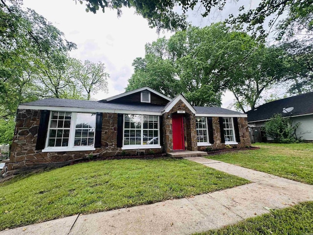 ranch-style home with a front lawn and stone siding