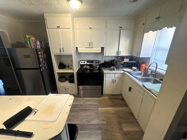kitchen with wood finished floors, a sink, under cabinet range hood, stainless steel appliances, and white cabinetry
