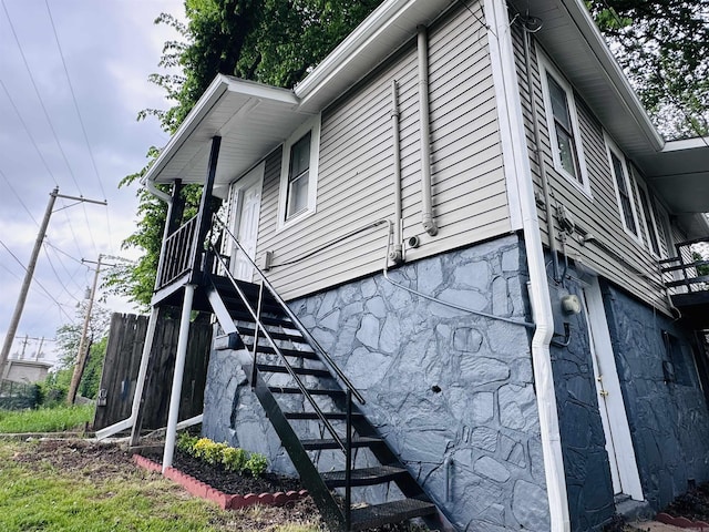 view of home's exterior featuring stairs and stone siding