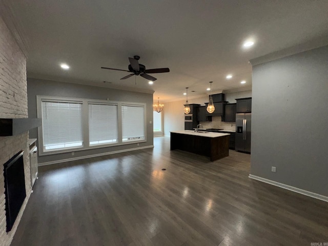 4321 Sloan, Alexander, AR 72002 - kitchen with stainless steel fridge, light countertops, ceiling fan with notable chandelier, open floor plan, and a center island with sink