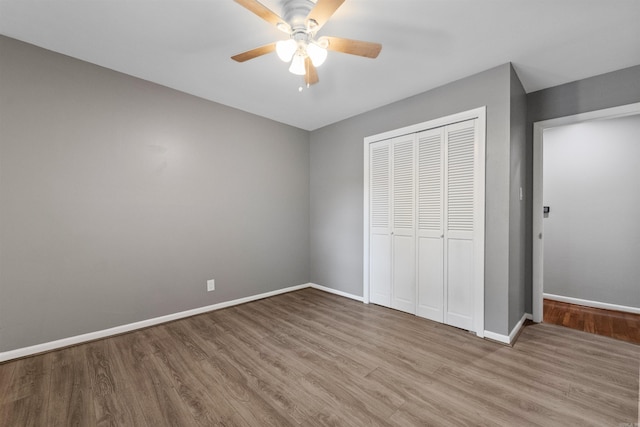 unfurnished bedroom with a closet, baseboards, ceiling fan, and wood finished floors