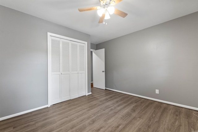unfurnished bedroom with baseboards, ceiling fan, a closet, and wood finished floors