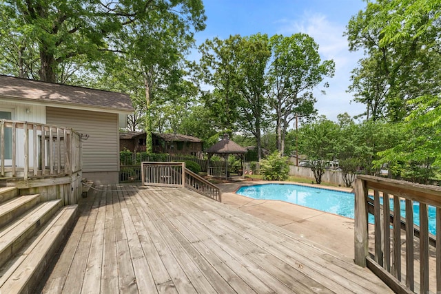 outdoor pool with a fenced backyard, a gazebo, and a deck
