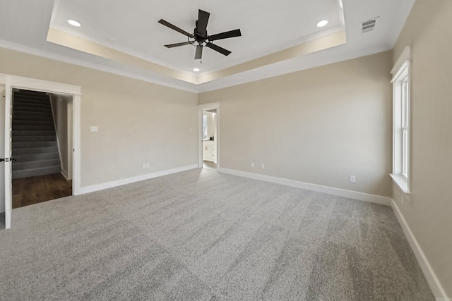empty room featuring carpet floors, baseboards, ceiling fan, recessed lighting, and a raised ceiling