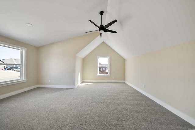 additional living space with vaulted ceiling, baseboards, a ceiling fan, and carpet flooring