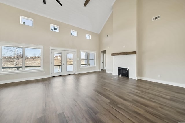 unfurnished living room featuring high vaulted ceiling, ceiling fan, baseboards, and dark wood-style flooring