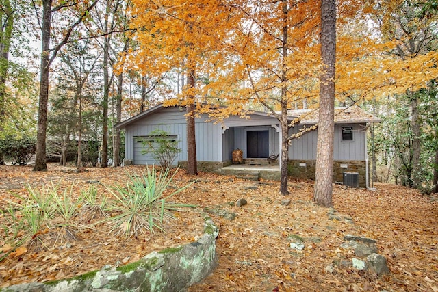 view of front facade featuring a garage, board and batten siding, and central AC