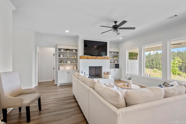 living room with light wood-style floors, ornamental molding, and baseboards