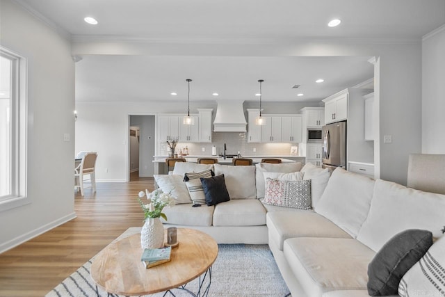 living room featuring recessed lighting, baseboards, and light wood-style flooring